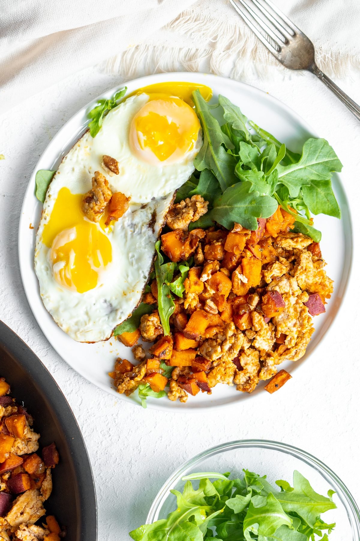Eggs, greens, and turkey sweet potato hash on a plate.