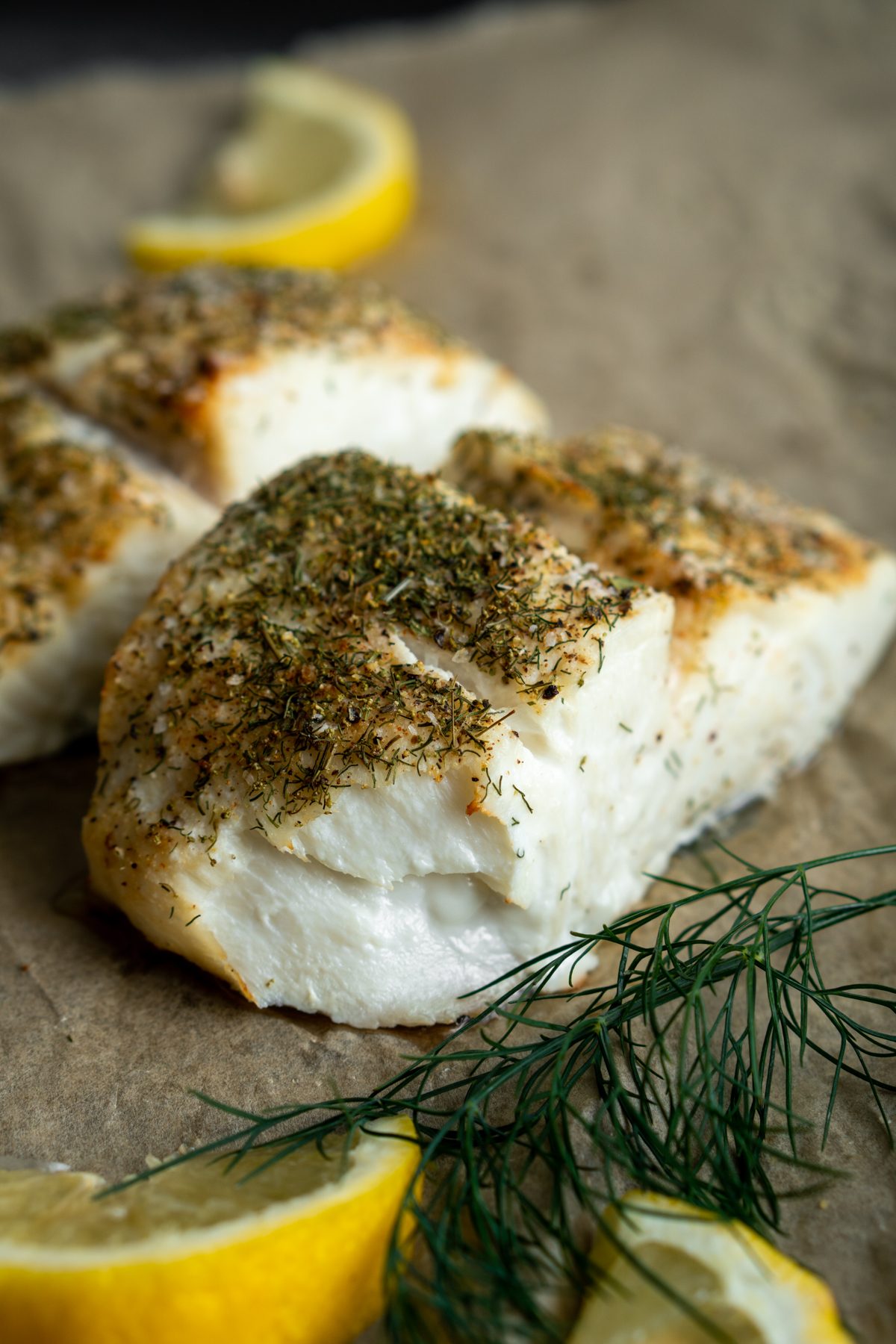 Parchment paper topped with halibut.