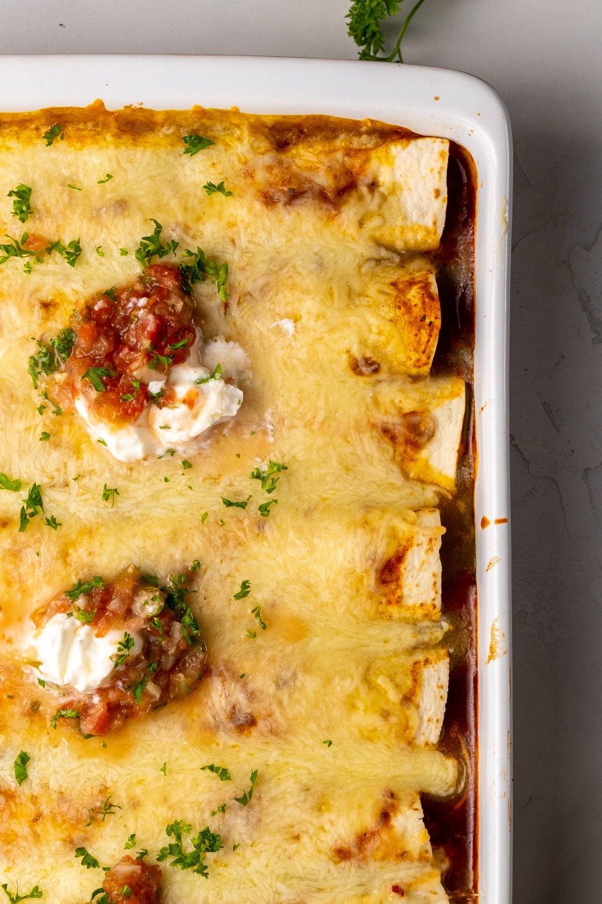 Chili Cheese Enchiladas topped with sour cream and salsa.
