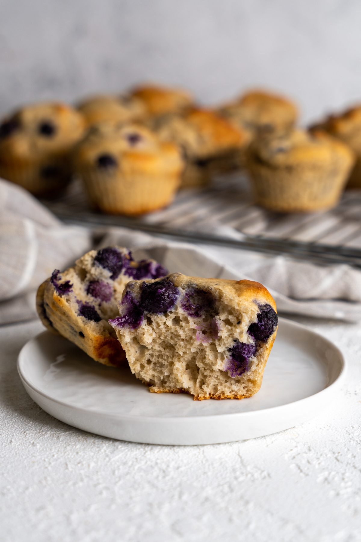 Two halves of protein blueberry muffins on a small plate.