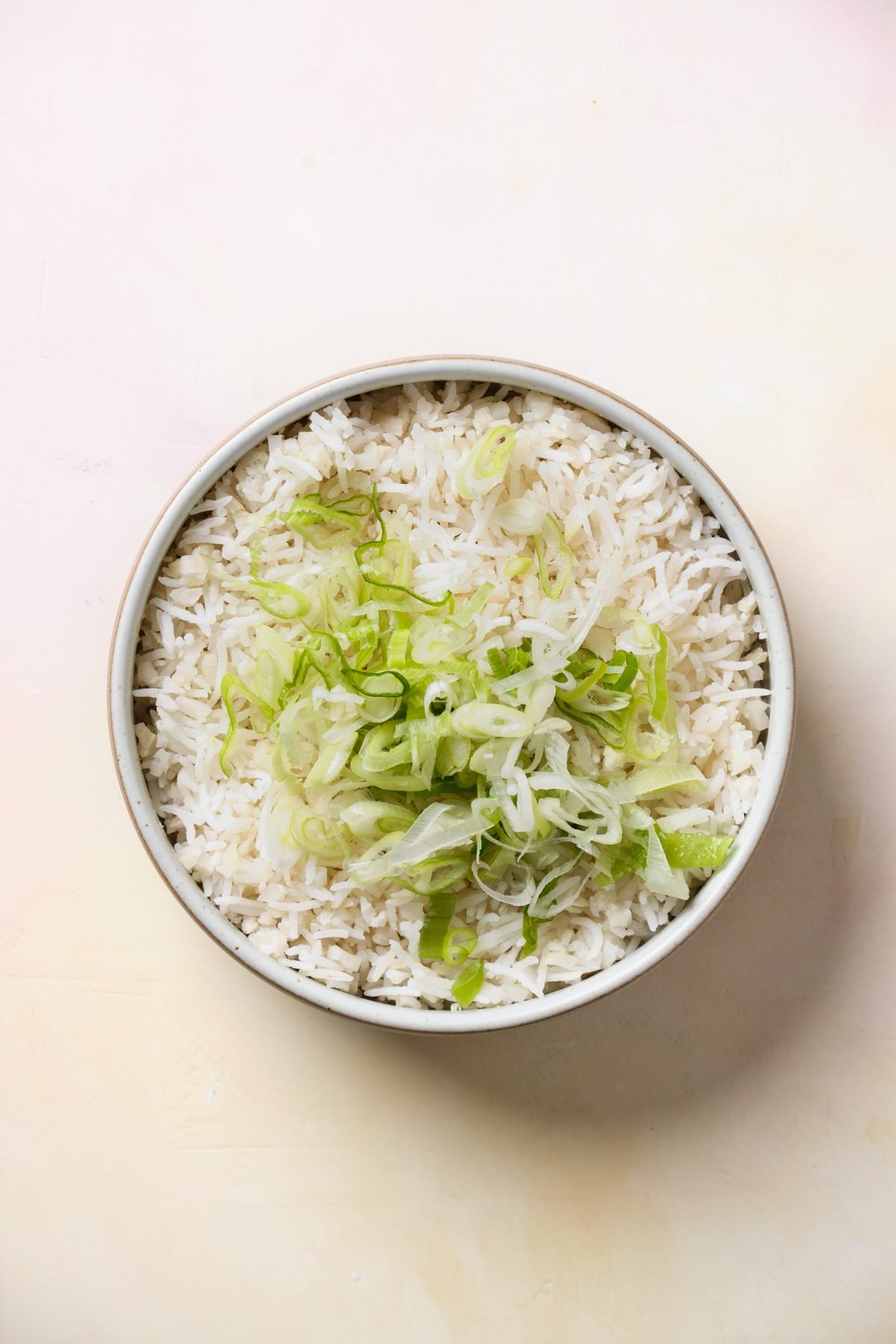 Rice topped with sliced green vegetables.