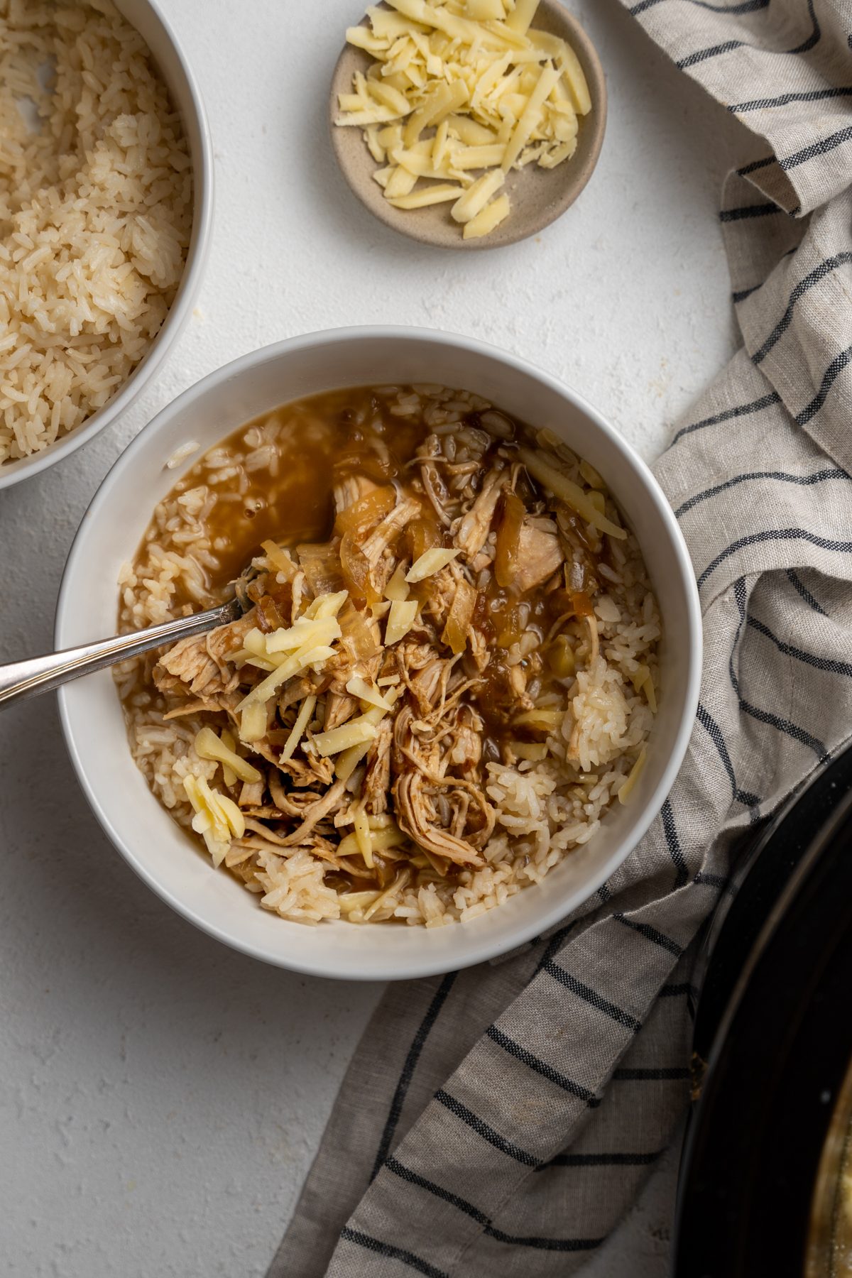 Spoon in a bowl of French onion chicken over rice.