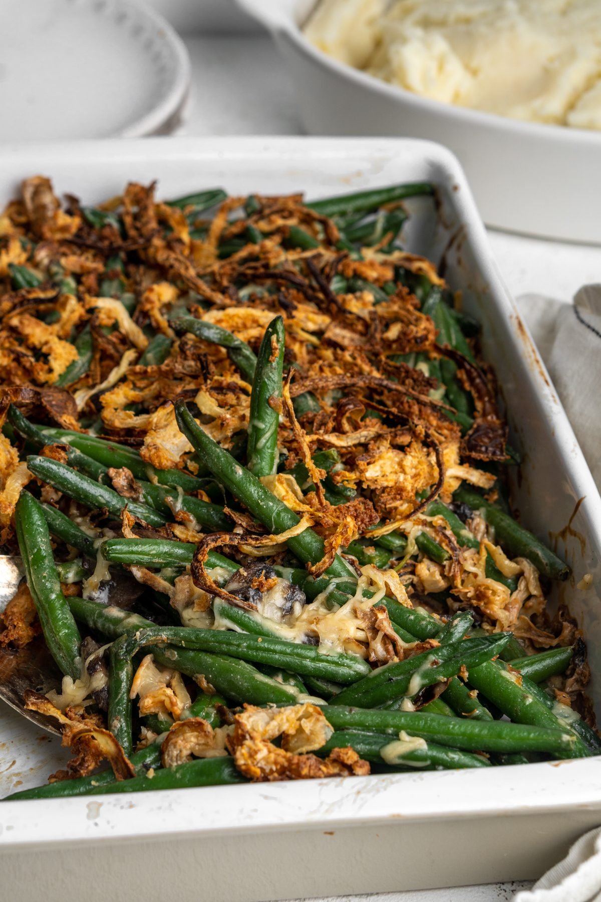 Green bean casserole with cheese and crispy fried onions on top. 