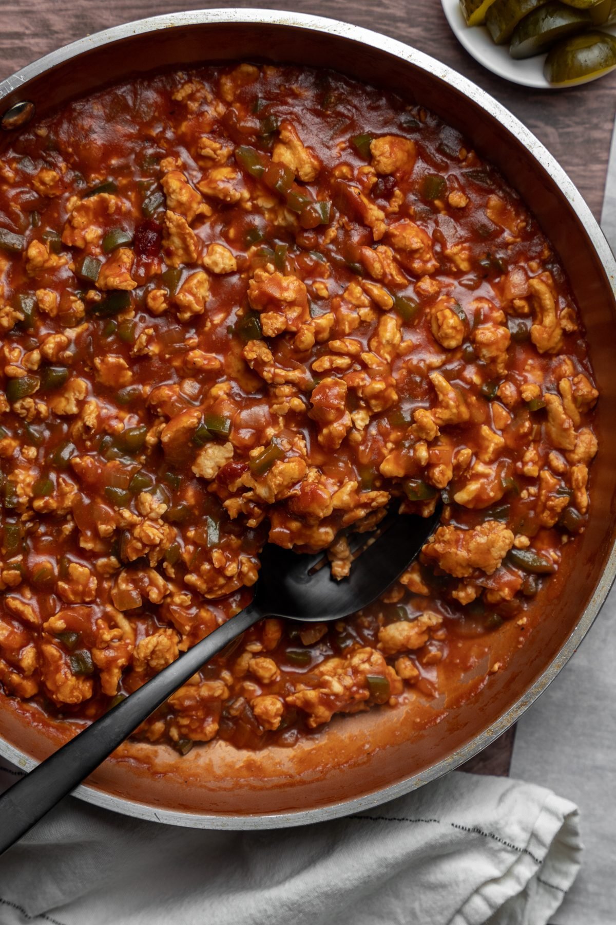 Spoon in a pan of ground chicken sloppy joe mix.