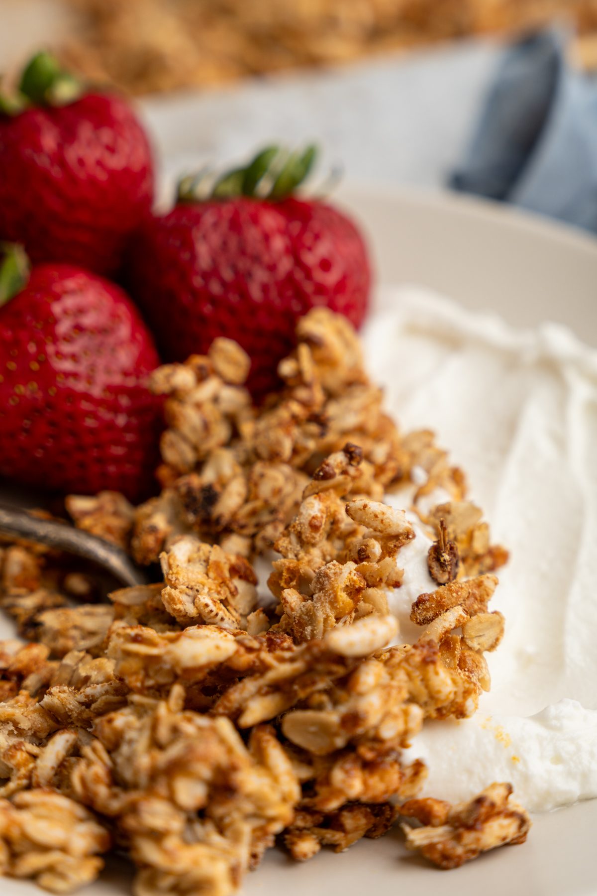 Vanilla granola on a plate with yogurt and strawberries.
